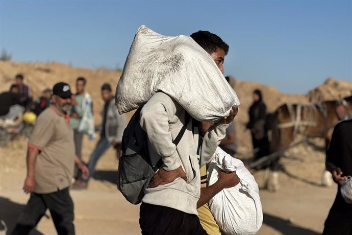 Personas cargando sacos en el desierto
