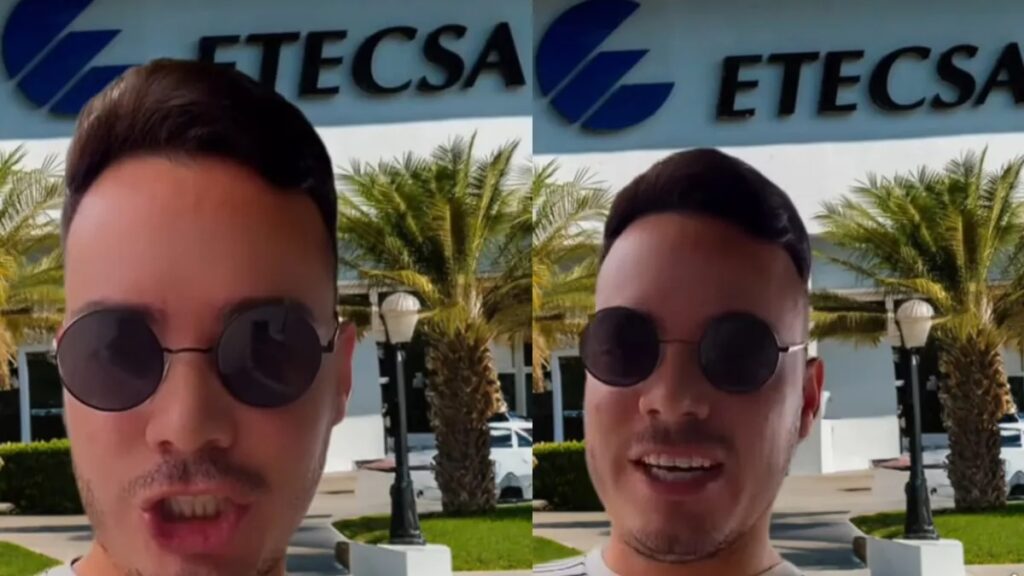 Persona delante de edificio ETECSA, palmeras alrededor.