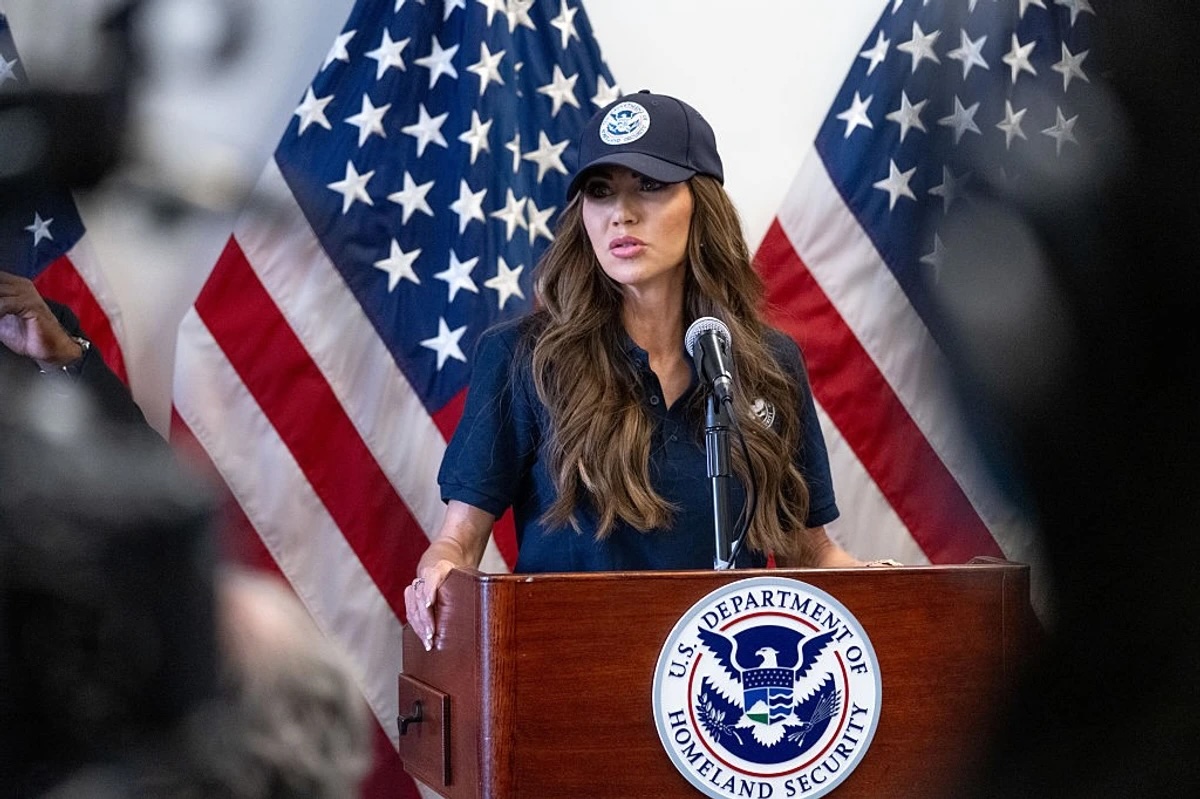 Persona hablando en conferencia con banderas estadounidenses