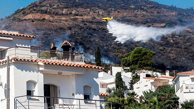 Avión extinguiendo incendio forestal en montaña.