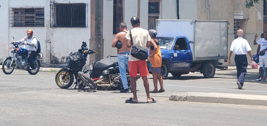 Encuentro en la calle con motos y transeúntes.
