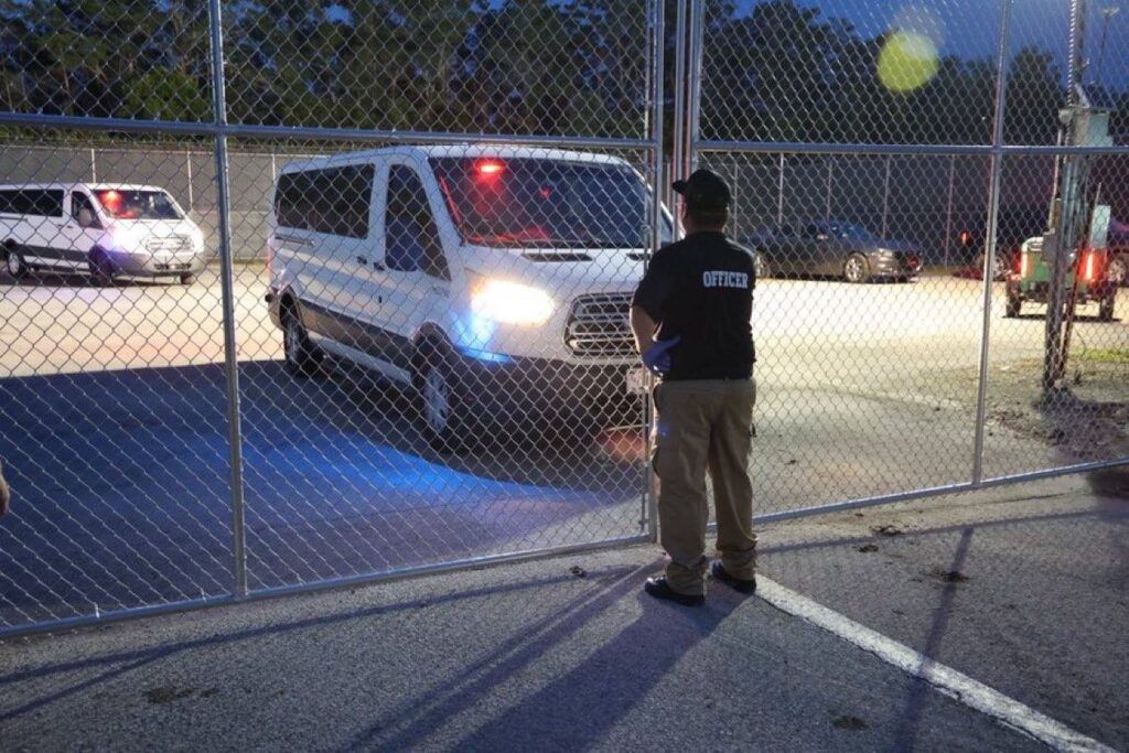 Oficial cerrando puerta de reja en estacionamiento