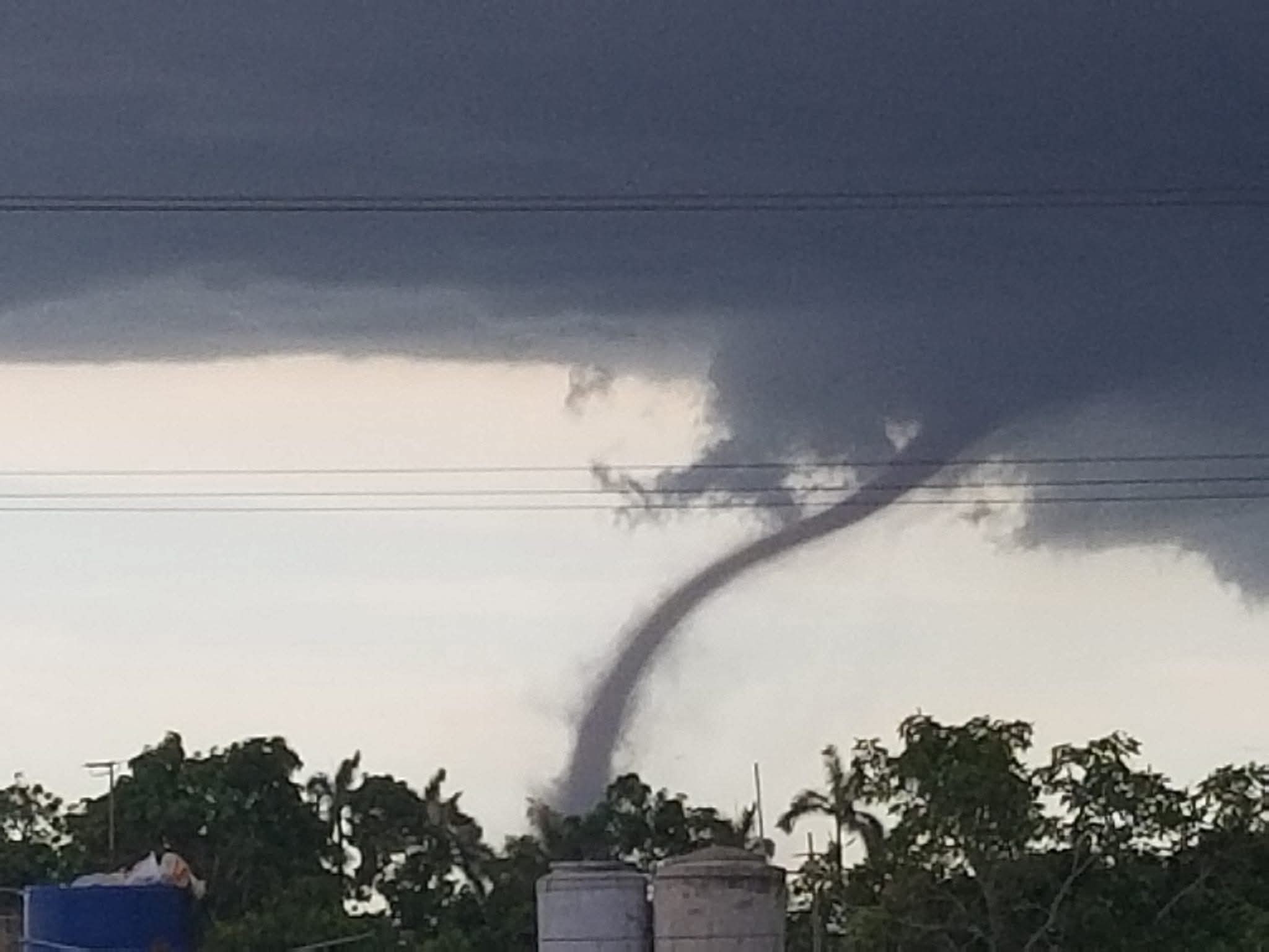 Tornado formándose sobre el campo con nubes oscuras.