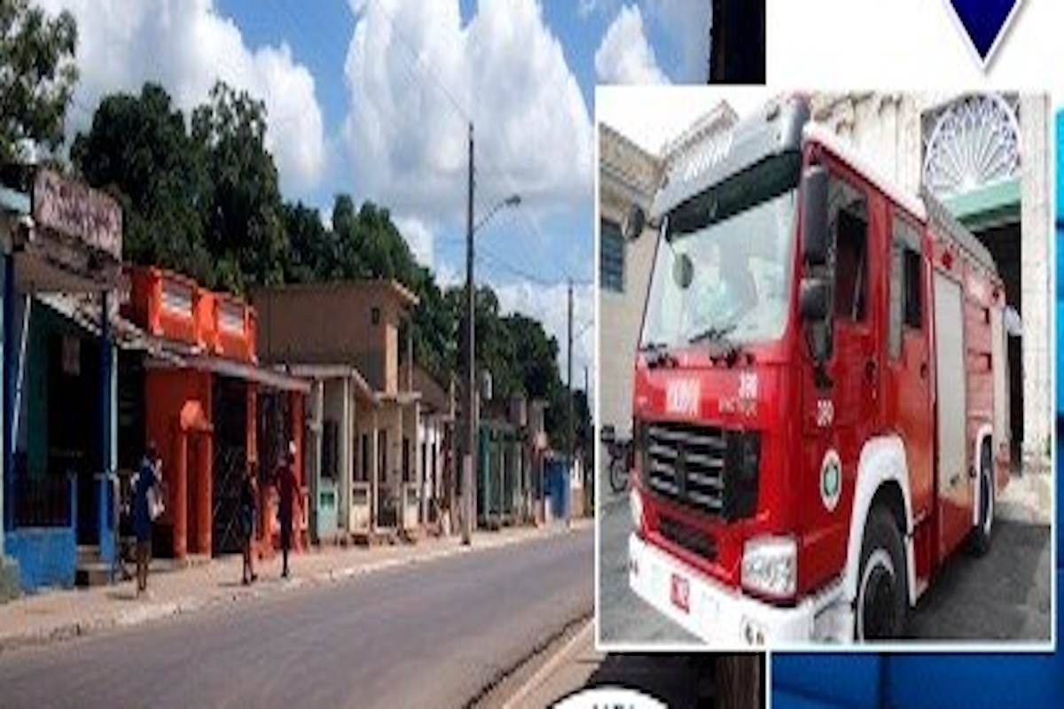 Calle con camión de bomberos rojo y edificios.