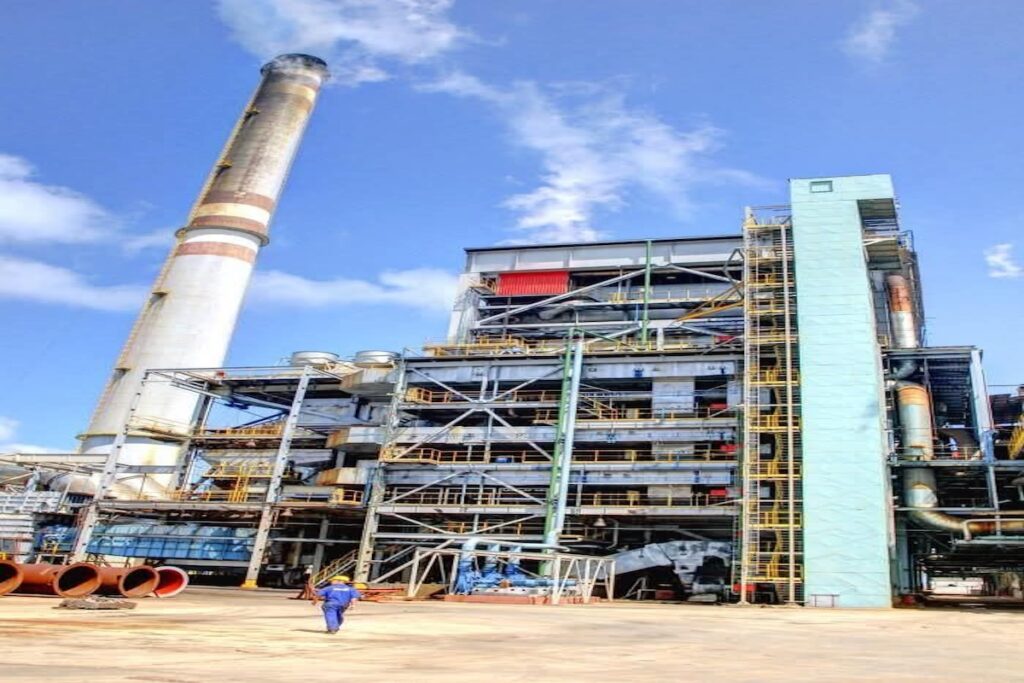 Planta industrial con chimenea y cielo despejado