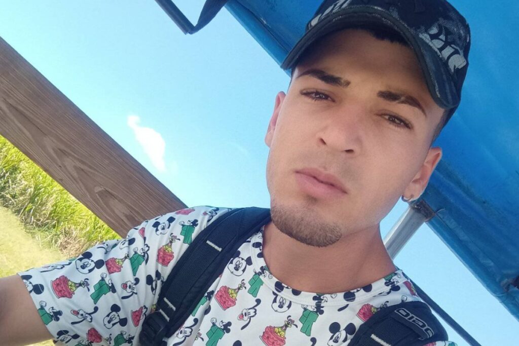 Persona con gorra bajo techo azul exterior.