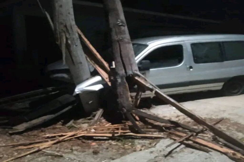 Furgoneta chocada contra un poste de madera.