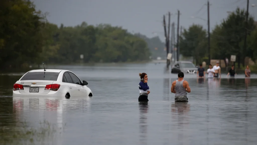 Coches y personas en calle inundada