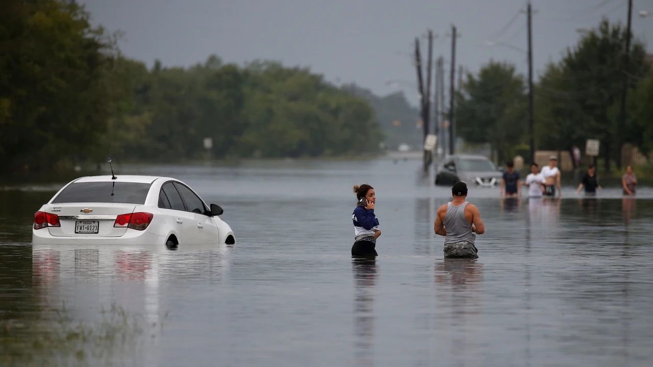 Coches y personas en calle inundada