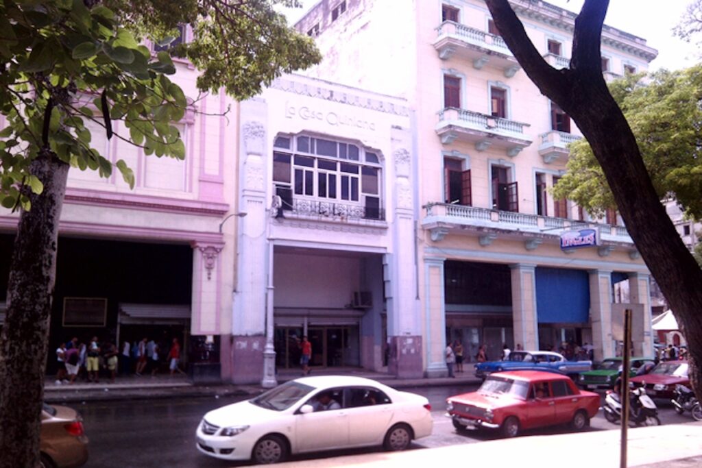 Fachada de edificio histórico en calle concurrida.