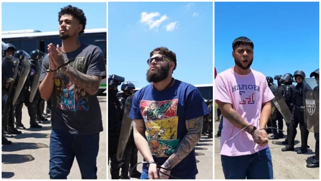 Hombres arrestados frente a policías antidisturbios.