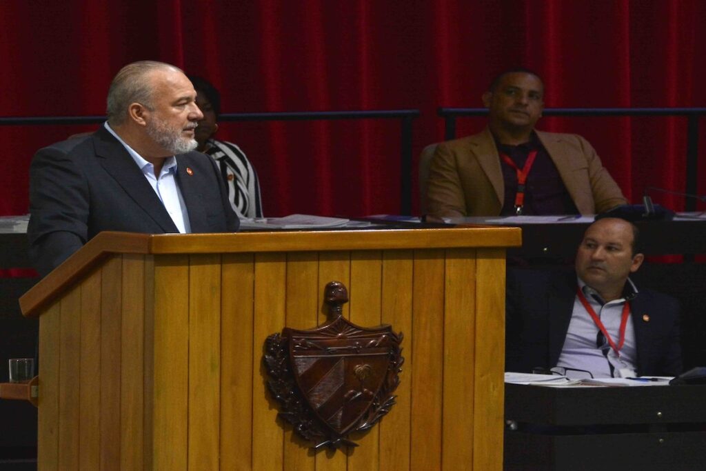 Hombre hablando en un podio con personas sentadas detrás.