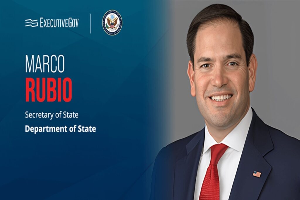 Hombre sonriente con traje y corbata, logo oficial.