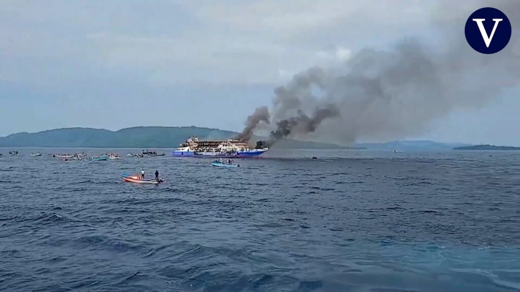 Ferry incendiado en el mar, humo visible desde lejos.