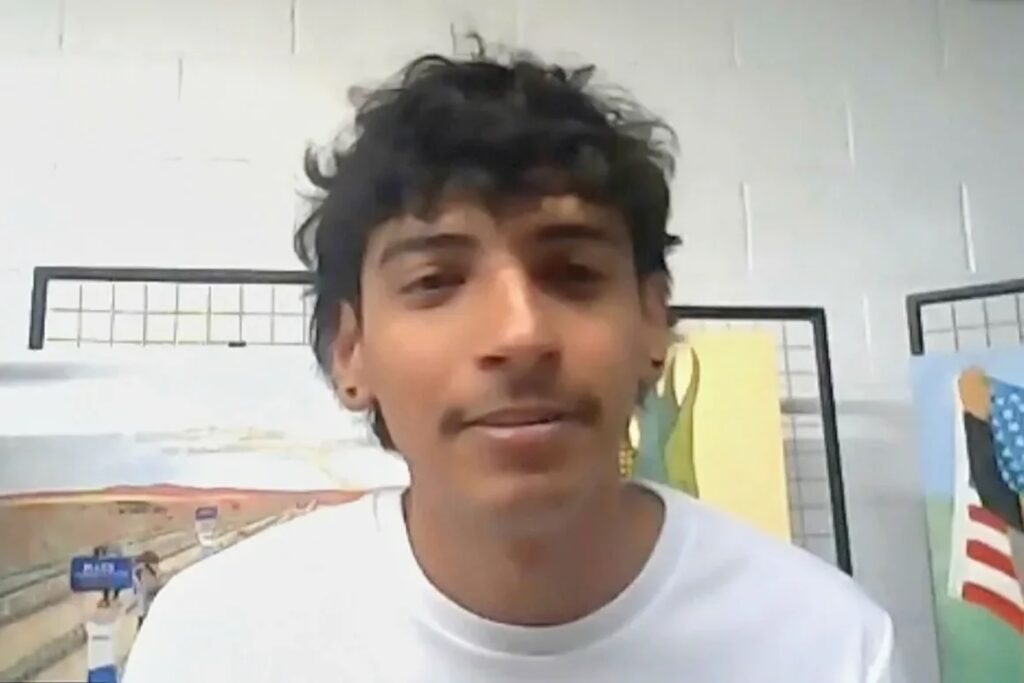 Persona frente a fondo artístico colorido.