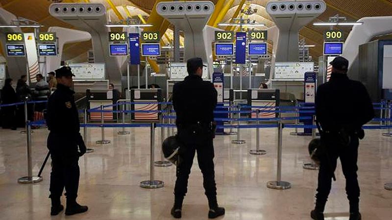 Policías supervisando control de seguridad en aeropuerto.