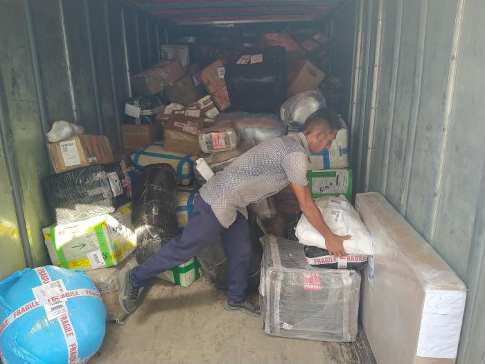 Hombre organizando paquetes en camión de carga