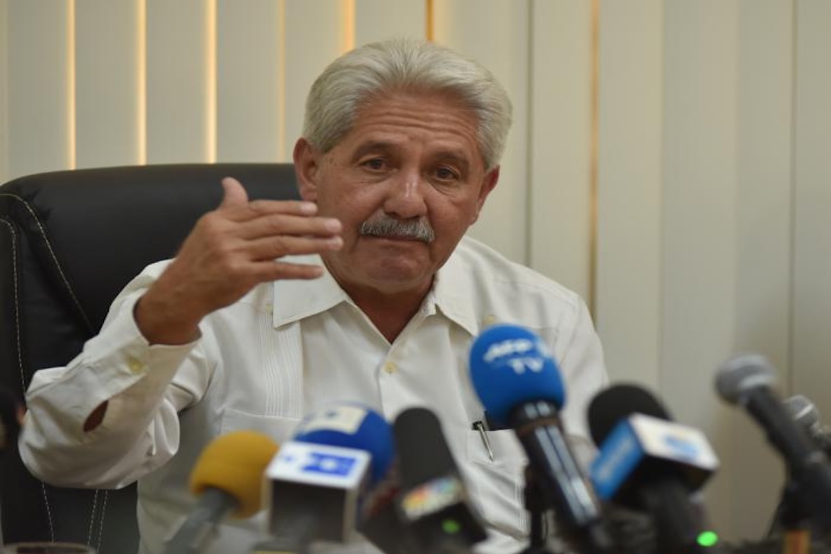 Hombre mayor en rueda de prensa con micrófonos