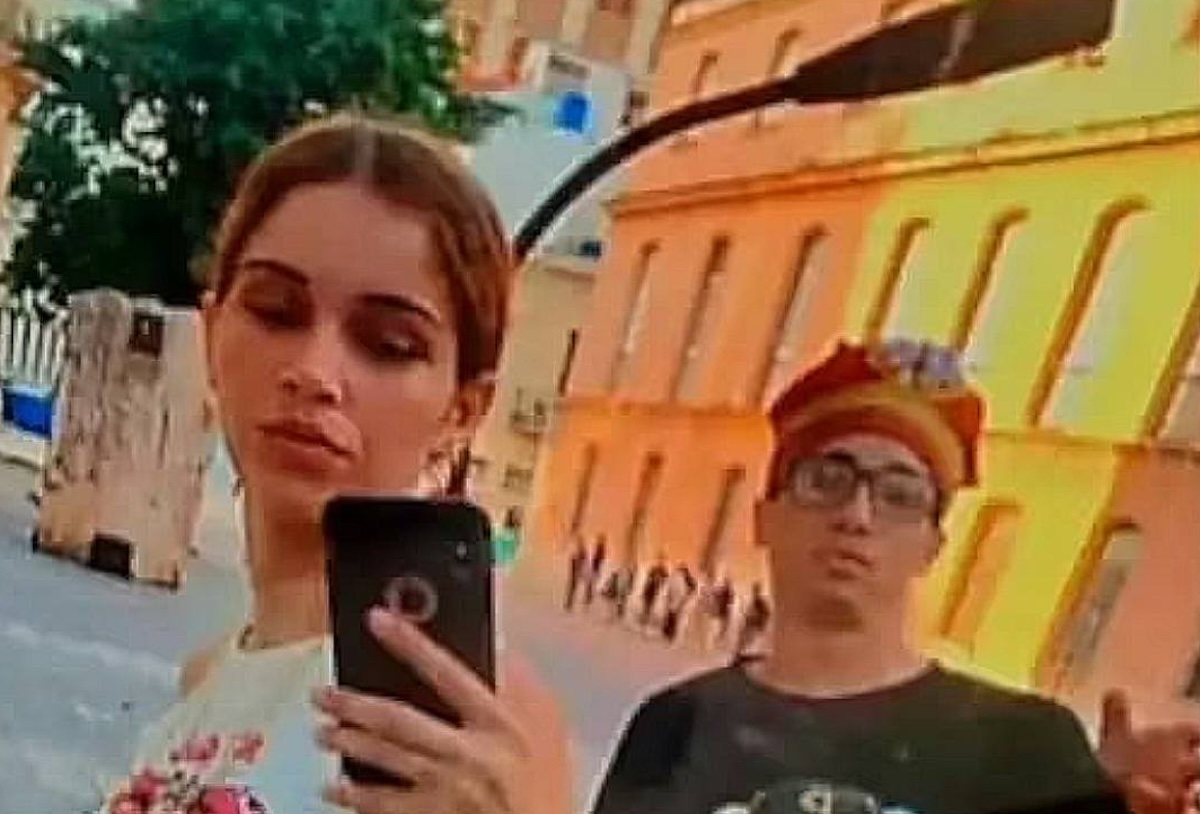 Dos personas posando en la calle con edificios.