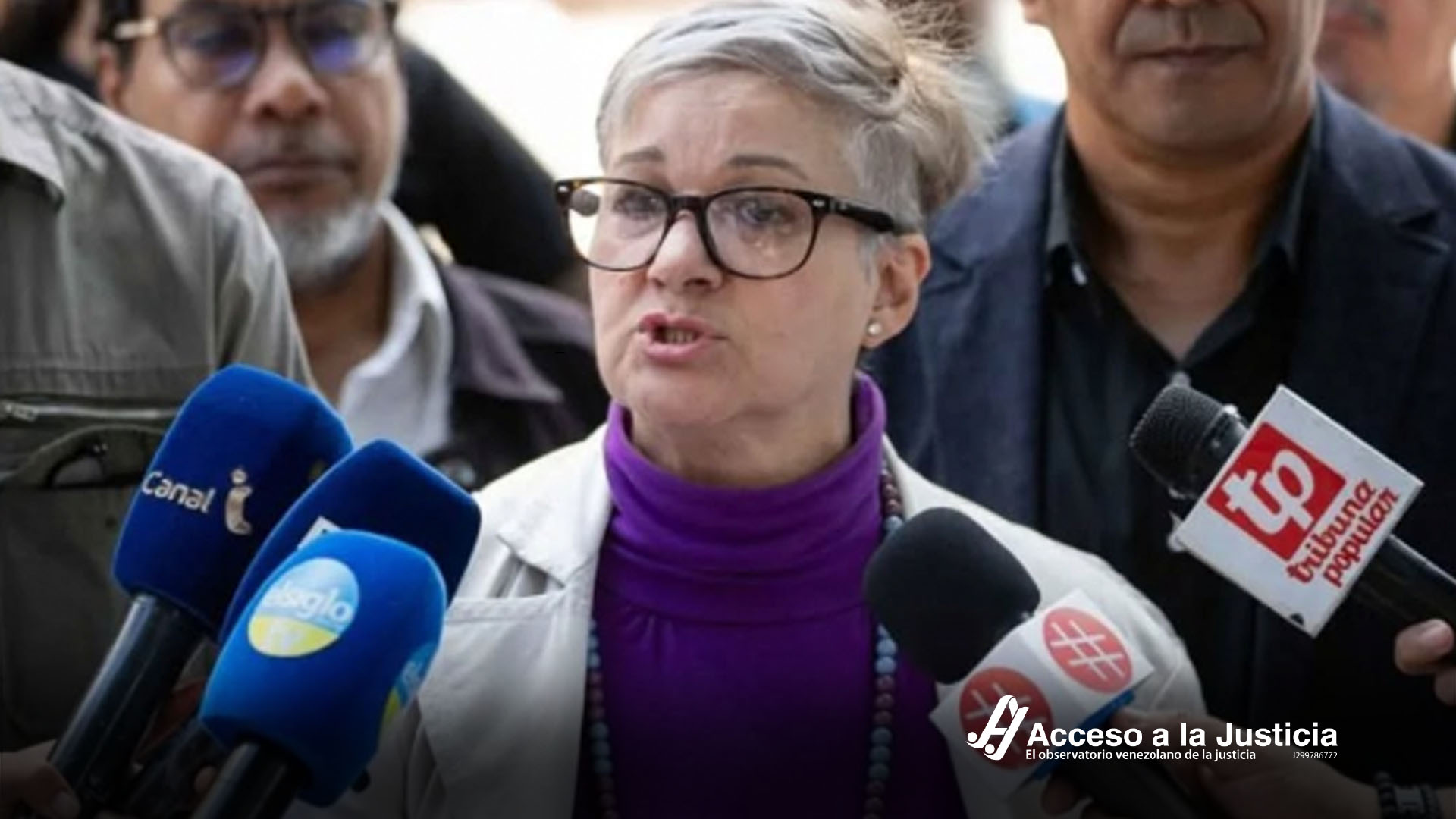 Mujer dando declaración a prensa con micrófonos