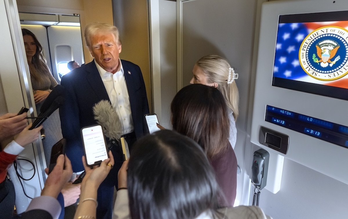 Donald Trump hablando con periodistas a bordo de un avión.