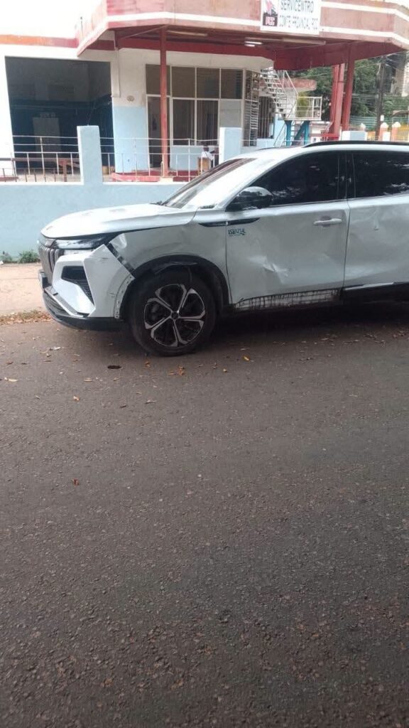 SUV blanco con daños por colisión en el lateral delantero.