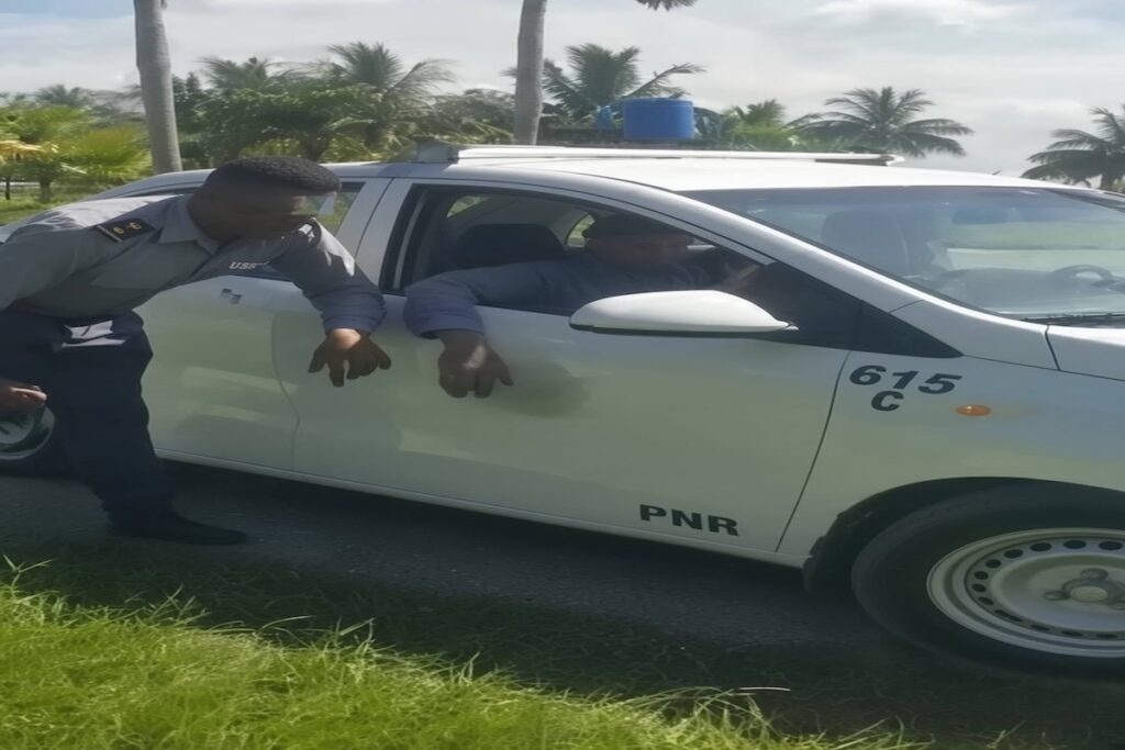 Agente de la PNR conversando junto a un coche patrulla.