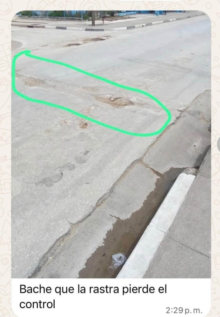 Bache profundo en asfalto señalizado con un círculo verde.