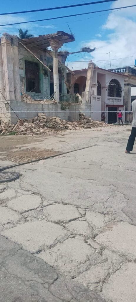 Edificio antiguo derrumbado con escombros en la calle.