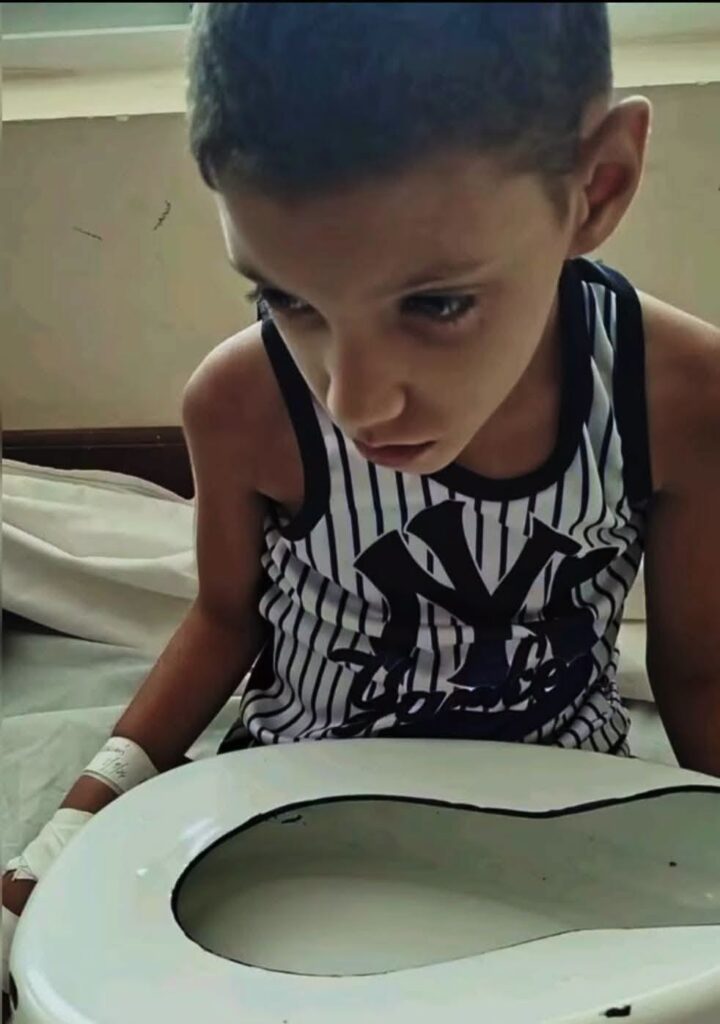 Niño con mirada triste y vendajes en un entorno hospitalario.