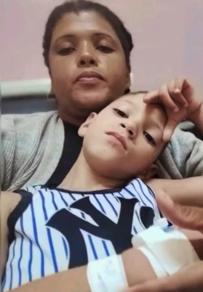 Mujer abrazando a niño con vendaje médico en el brazo.