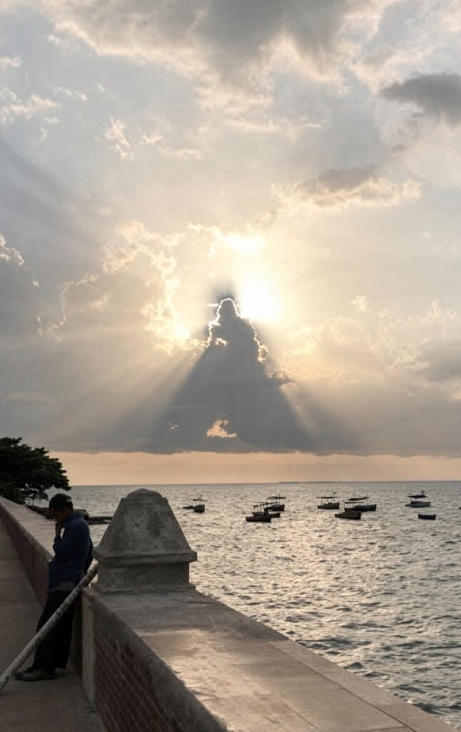 Atardecer sobre el mar con rayos solares filtrándose entre nubes.
