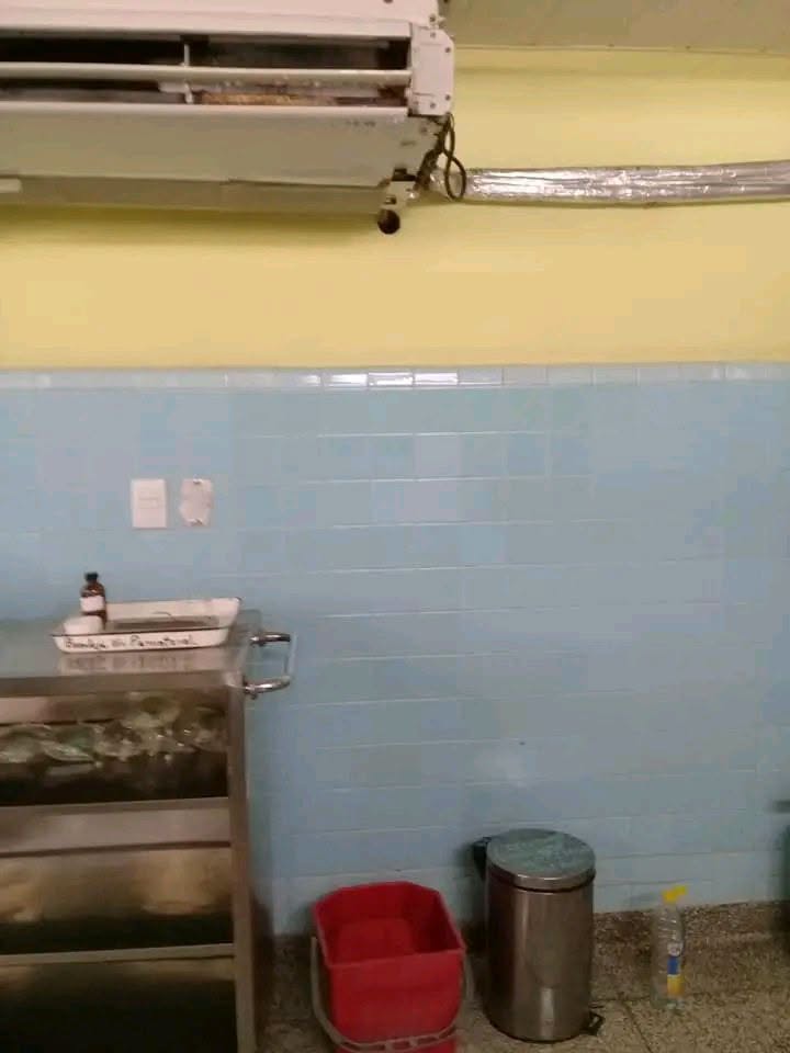 Carrito médico de acero frente a pared de azulejos azules.