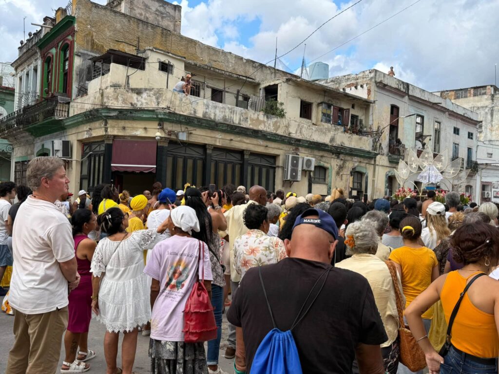 Multitud congregada en una calle histórica frente a edificios antiguos.