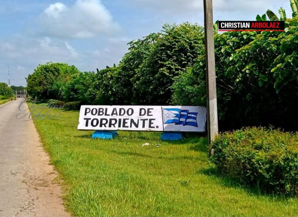 Letrero blanco de bienvenida al Poblado de Torriente, Cuba.