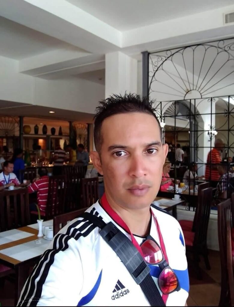 Primer plano de hombre con camiseta Adidas en un restaurante