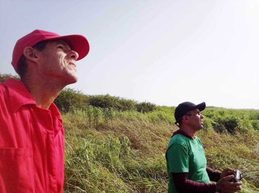 Dos hombres mirando al cielo mientras operan un dron.