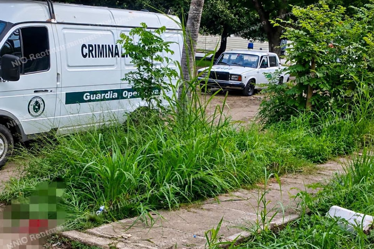 Vehículos de criminalística y policía investigando una escena del crimen.