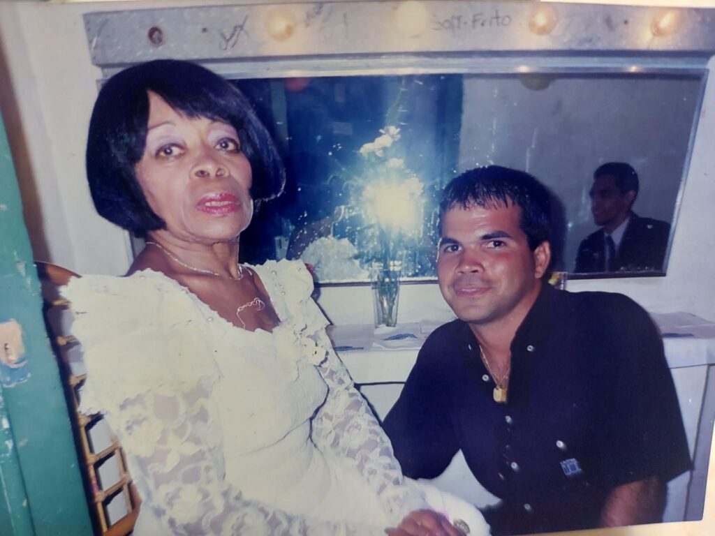 Mujer con vestido de encaje blanco y hombre joven posando.