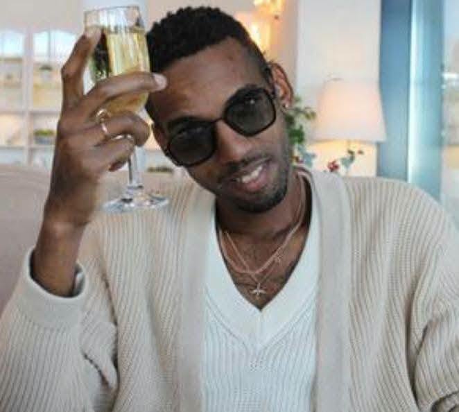 Hombre con gafas de sol brindando con copa de champán.
