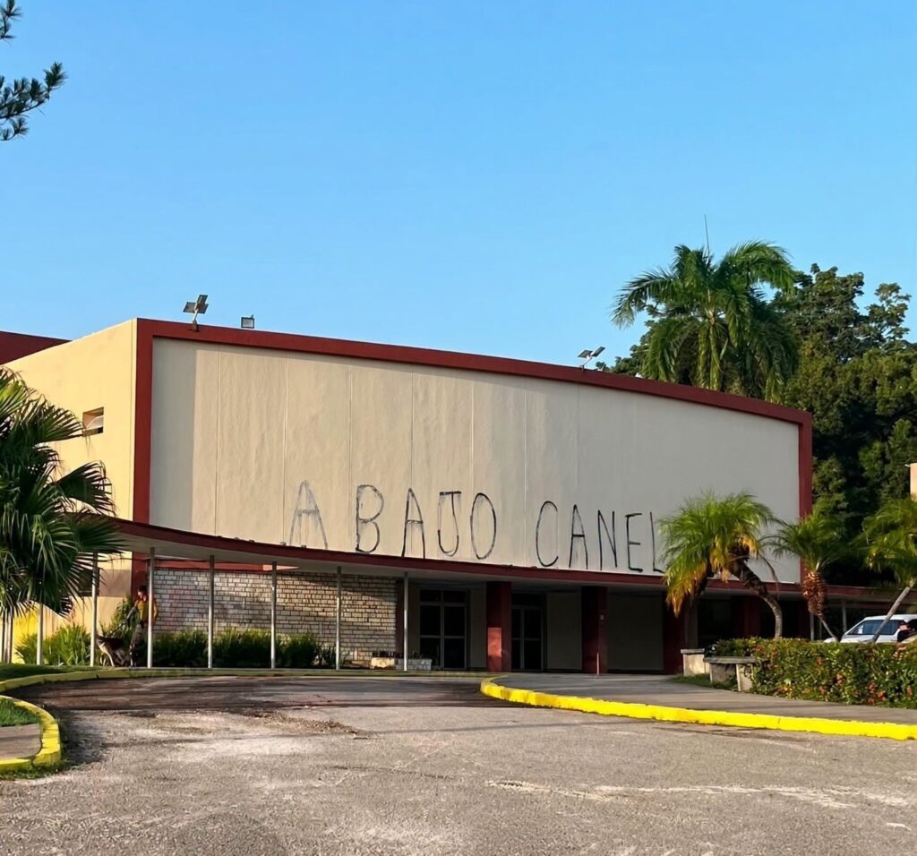 Graffiti 'ABAJO CANEL' en la fachada de un edificio público.