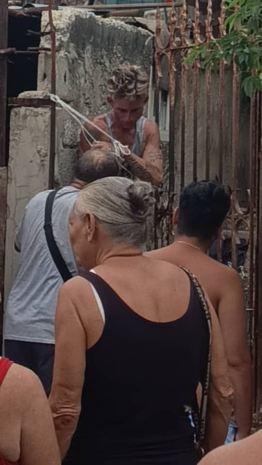 Personas en la calle mirando a un hombre con cuerdas.