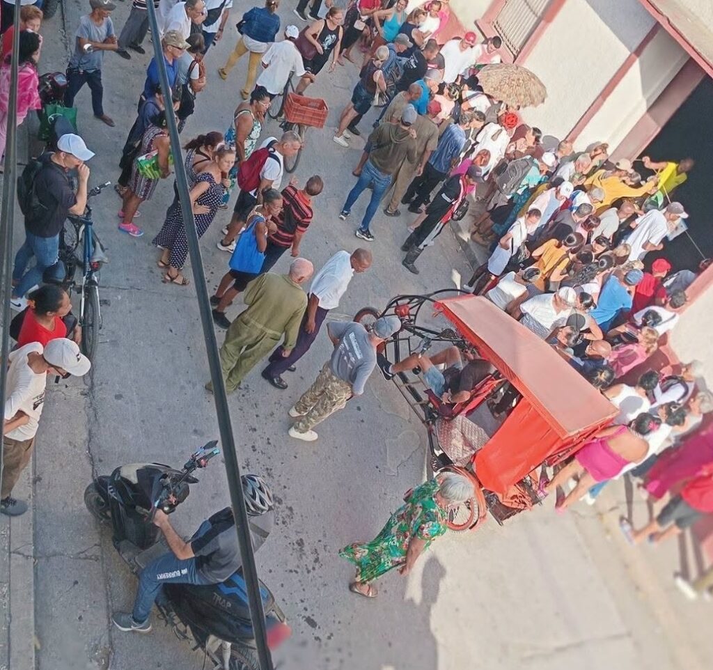 Vista aérea de una calle concurrida y gente haciendo cola.
