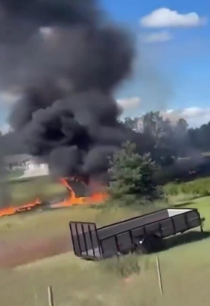 Gran columna de humo negro e incendio en campo abierto.