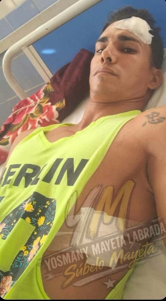 Hombre joven con vendaje en la frente tumbado en cama.
