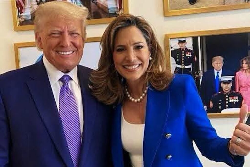 Donald Trump y mujer con chaqueta azul posando sonrientes.