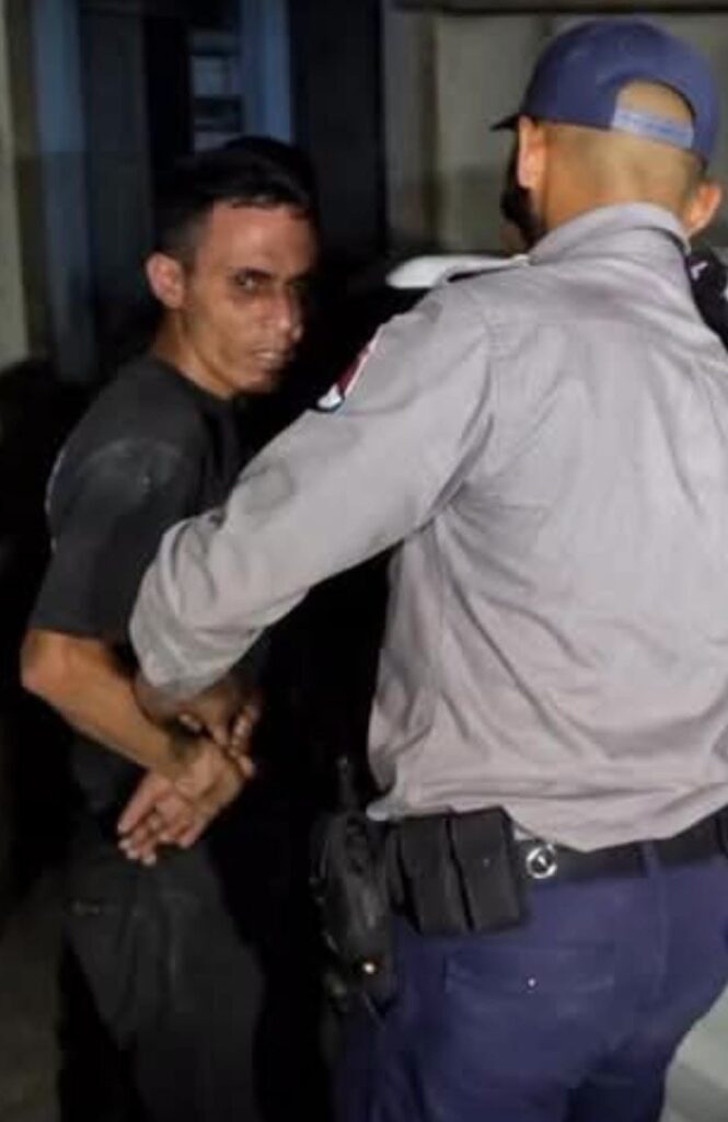Agente de policía esposando a un hombre joven arrestado.