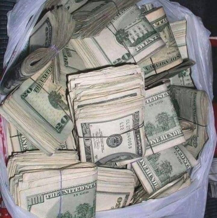 Bolsa de plástico blanca llena de fajos de dólares.