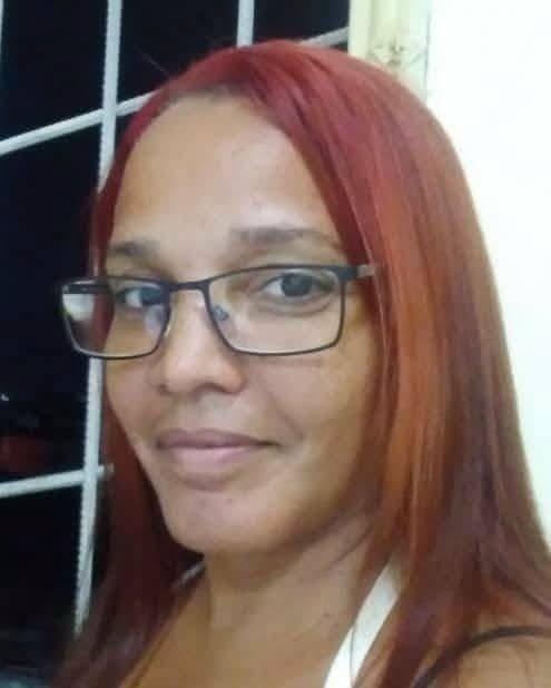 Mujer con gafas y pelo rojizo sonriendo a la cámara.