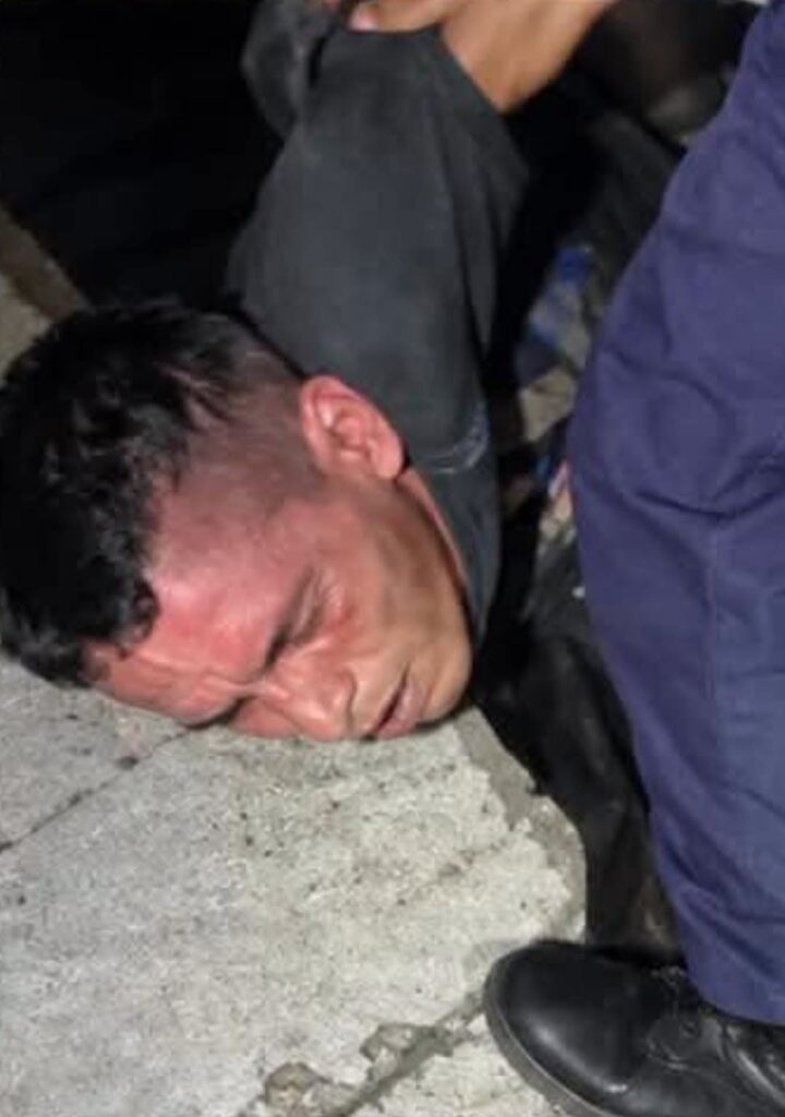 Hombre inmovilizado en el suelo durante una detención policial.